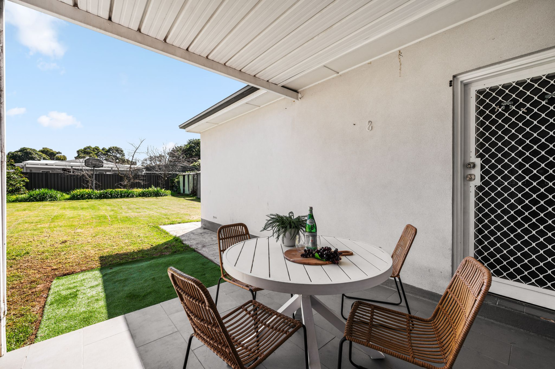 Covered rear verandah with outdoor dining setting overlooking the generous backyard